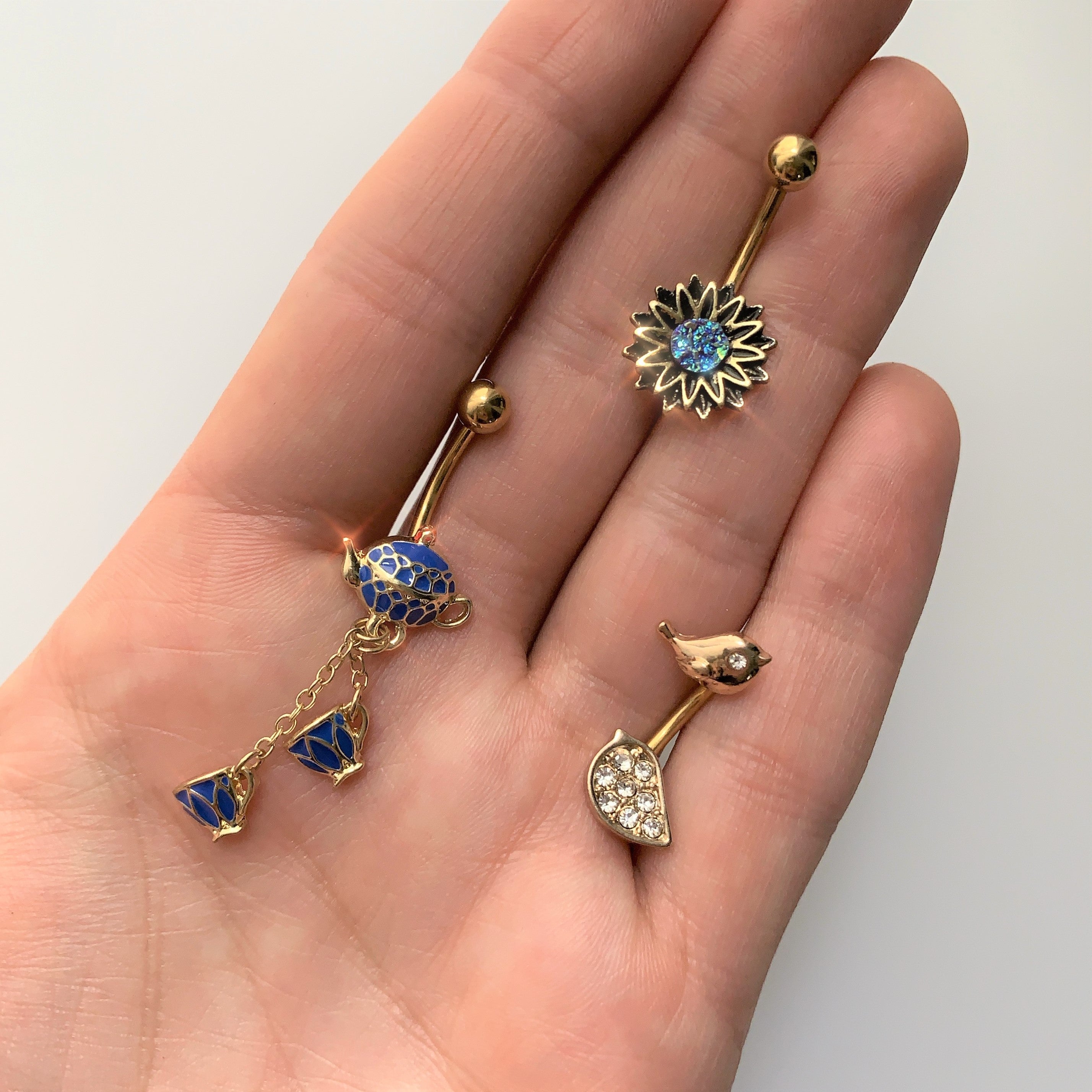 BodyCandy Gold Tone Aqua Center Sunburst Flower Belly Ring — detail close-up