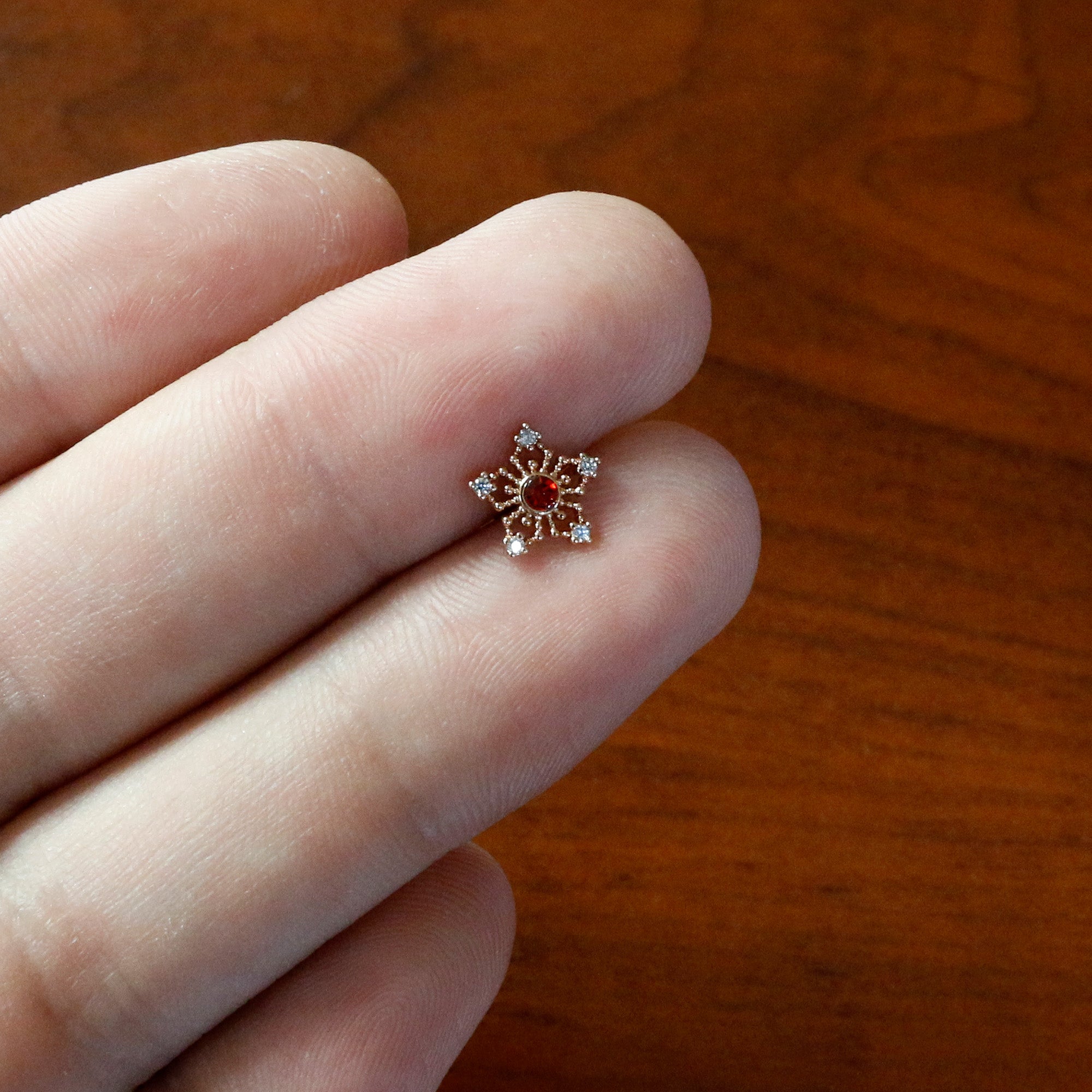 BodyCandy 16G 5/16 Red Gem Rose Gold Tone Texture Snowflake Labret Tragus — in-use photo