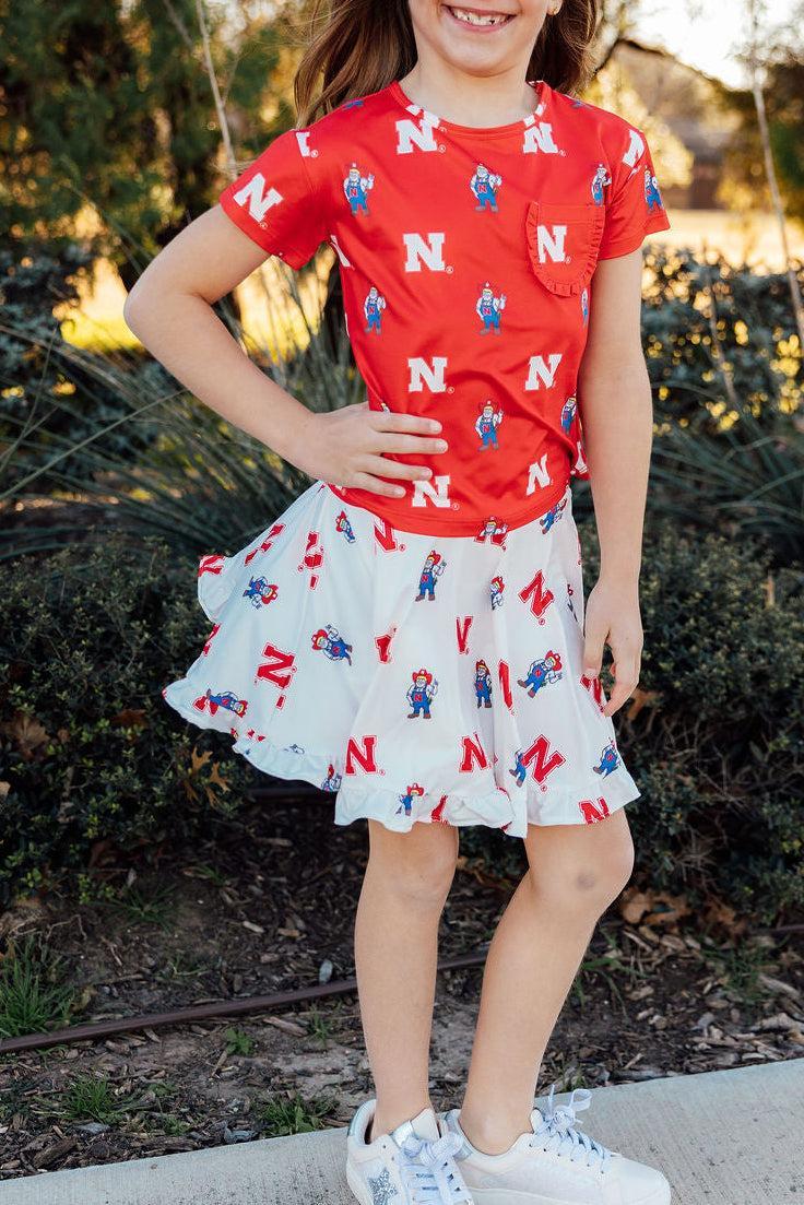 Mila & Rose ® Nebraska Red Herbie Husker Ruffle Pocket Tee — detail close-up